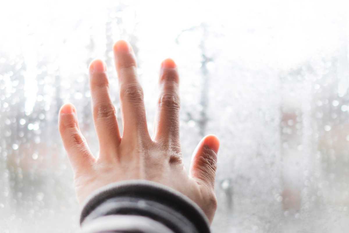 mano sul vetro umido di condensa