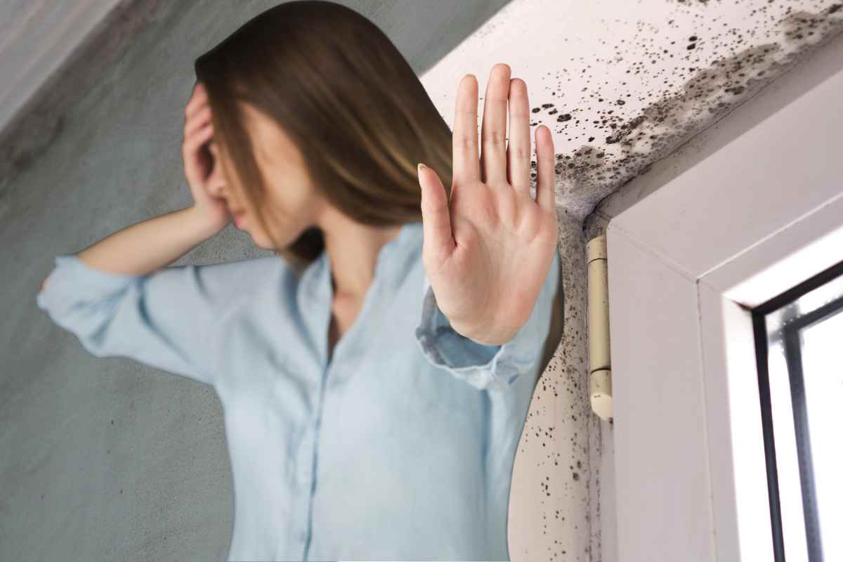 donna dice stop con la mano davanti a della muffa in casa