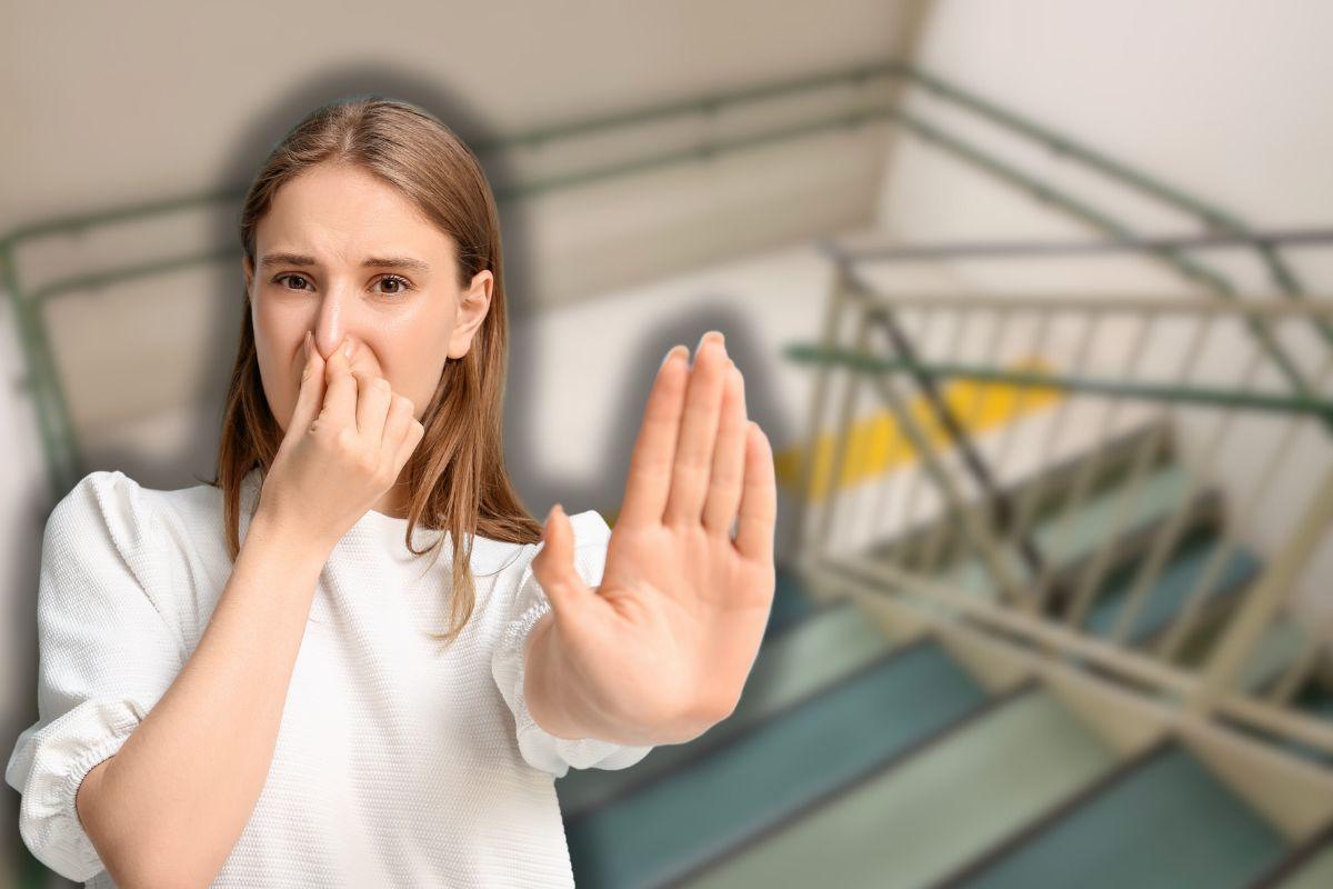 scale di un condominio e donna che sente cattivi odori