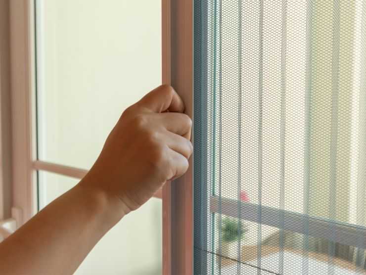 persona che apre zanzariera