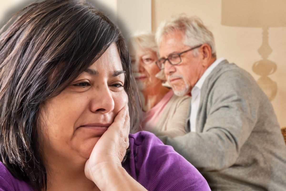 coppia di anziani sullo sfondo e donna triste in primo piano