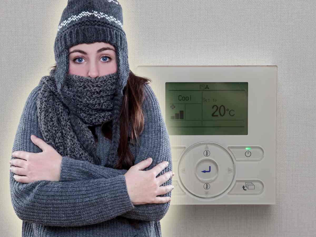 donna infreddolita e termostato a 20°