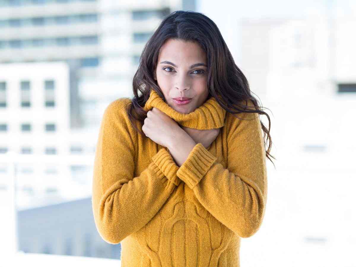 donna sente freddo e si stringe nel maglione