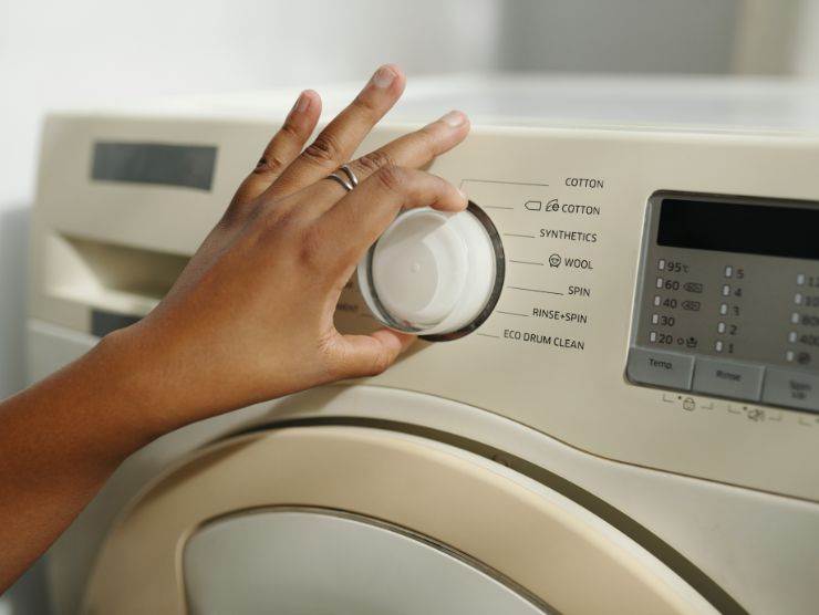 persona che imposta programma della lavatrice