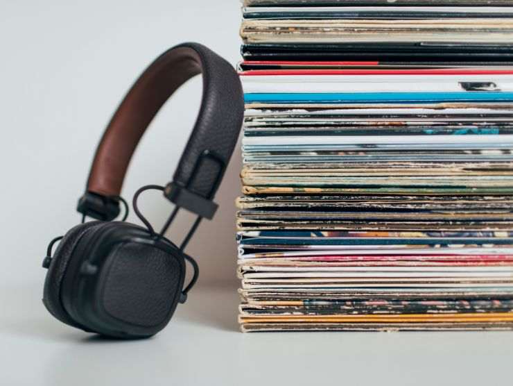 cuffie accanto ad una serie di dischi in vinile