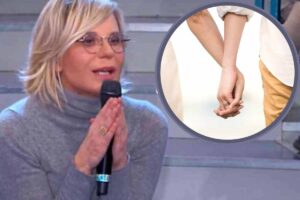 Maria De Filippi e nel cerchio una coppia mano nella mano