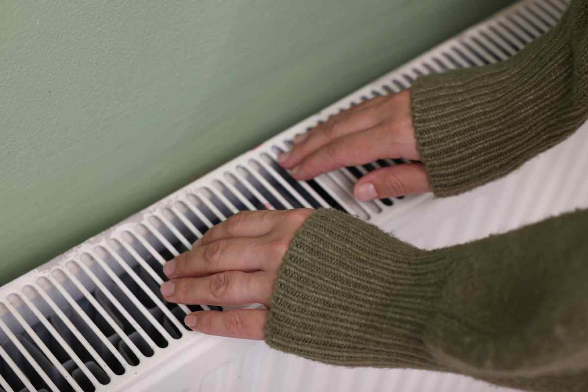 persona si scalda le mani sui radiatori