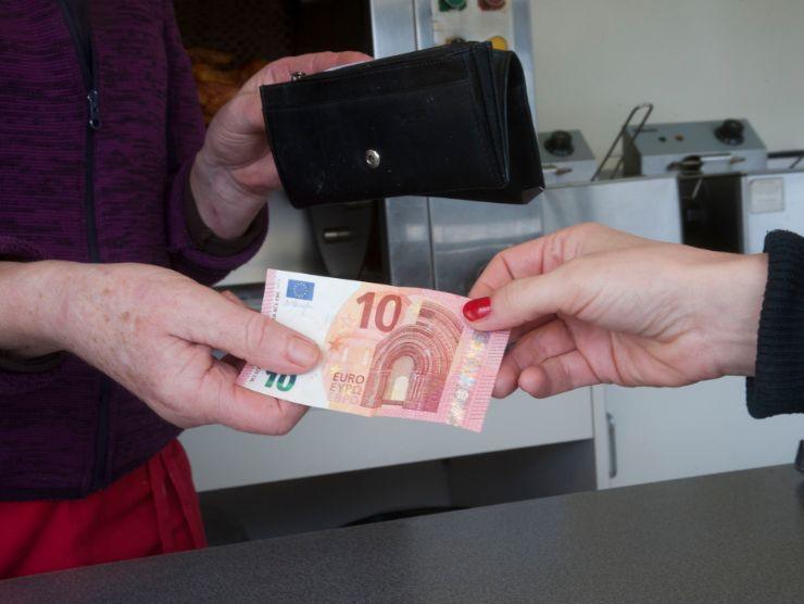 donna che paga con una banconota da 1 euro