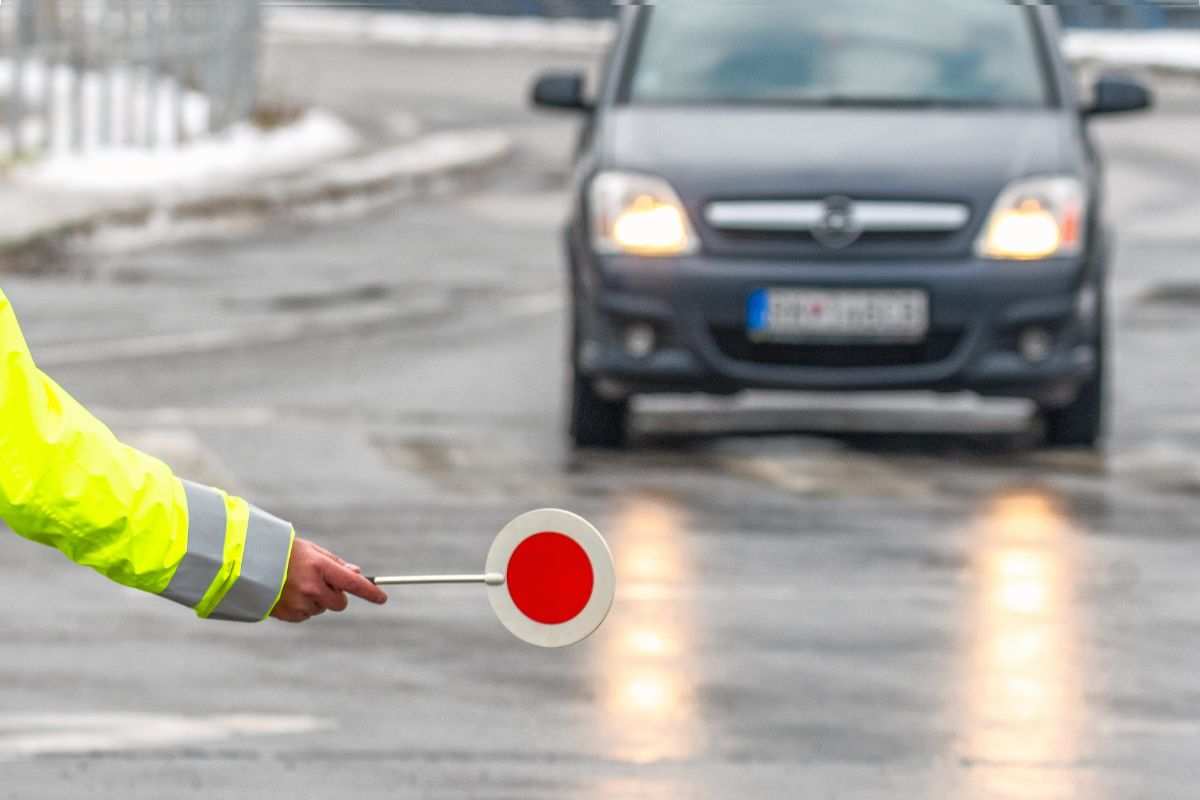 poliziotto che ferma auto per strada