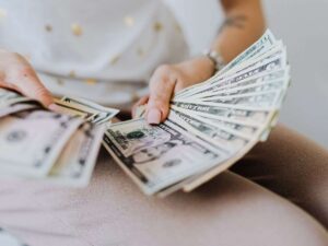 donna tiene in mano banconote