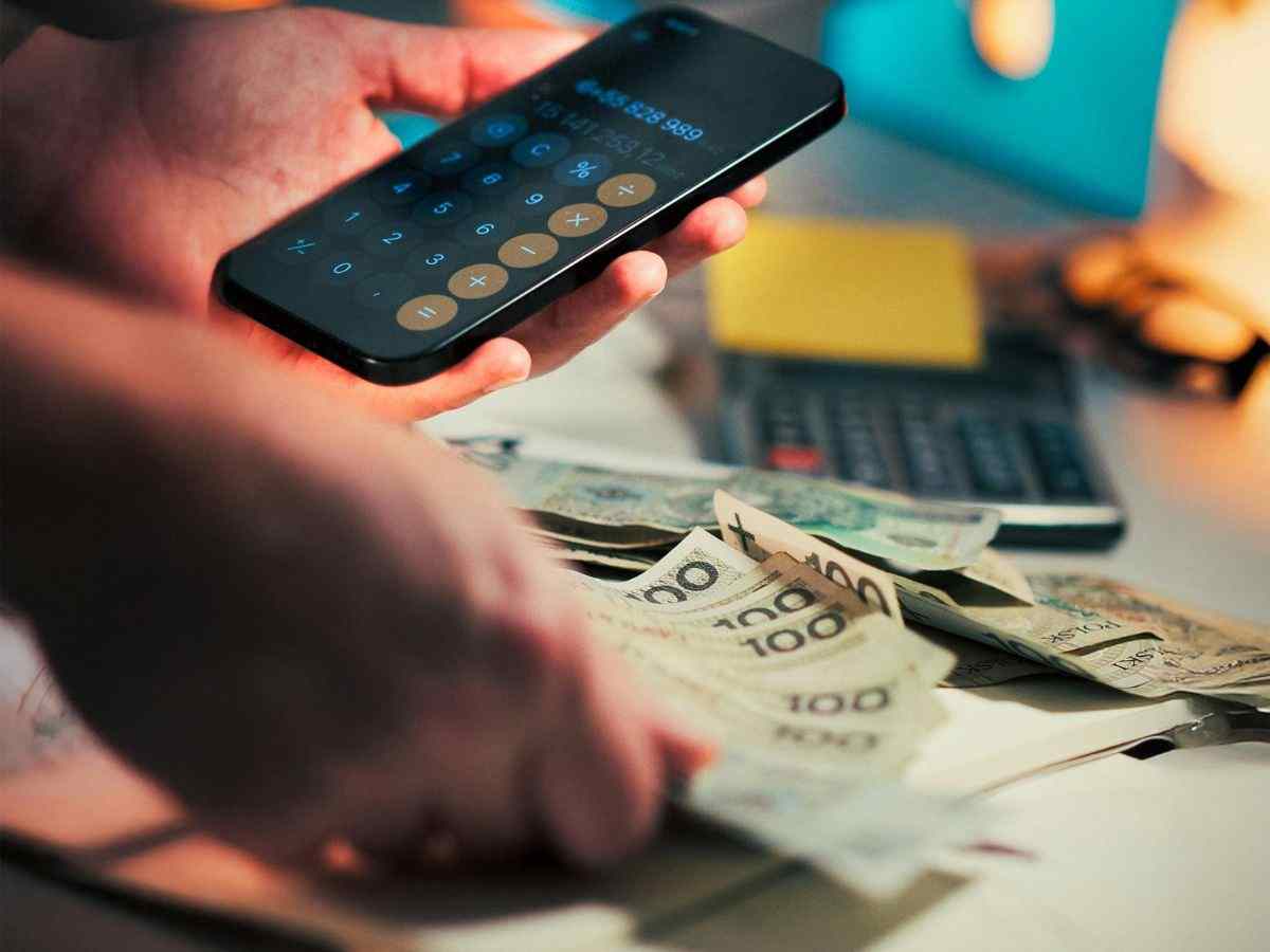 persona fa conti con calcolatrice e banconote